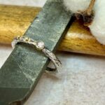 Anell de plata amb diamant i dos topets d'or groc